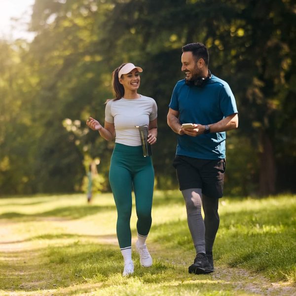 Happy,Athletic,Couple,Communicating,While,Walking,In,Nature,After,Sports Happy athletic couple communicating while walking in nature after sports training. Copy space.